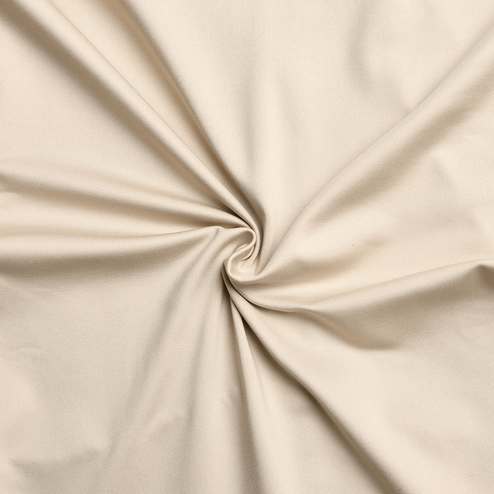 Soft beige fabric with a luxurious texture, gathered in a swirl pattern.